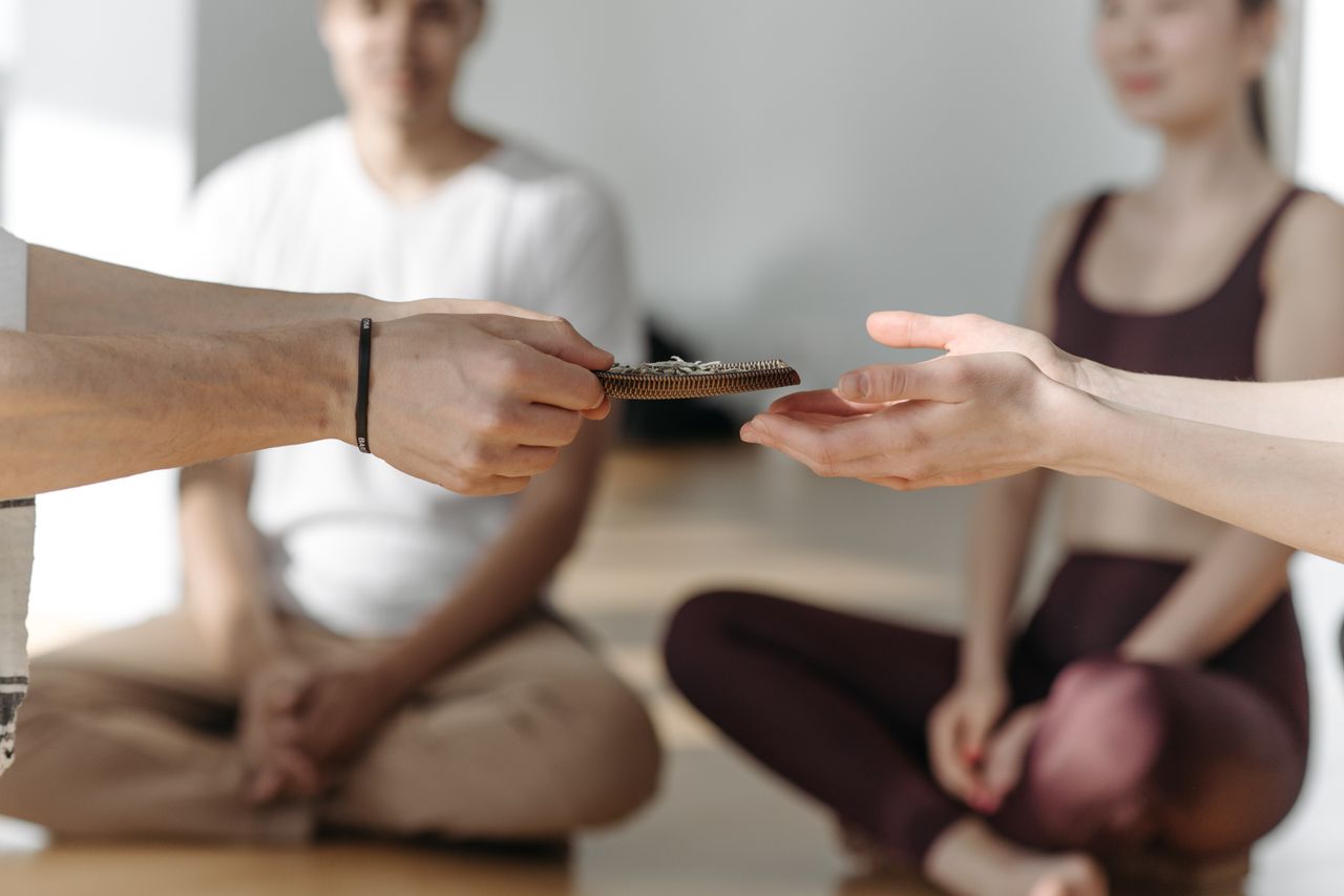 A serene group engaging in meditation with hands passing beads, promoting tranquility and mindfulness.